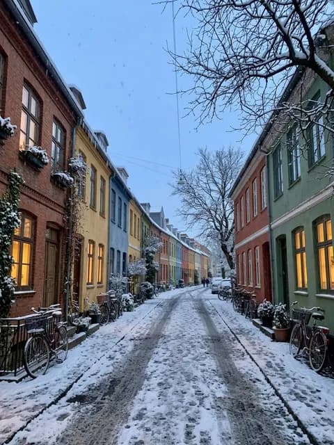 Eine Straße vor und nach der Bearbeitung „Winter zaubern“: dieselben Häuser im Schnee in der Abenddämmerung
